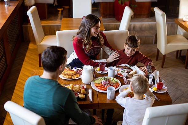 istock Kids enjoy breakfast together at a dining table with various foods and drinks 2263852134