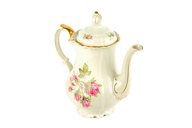 This exquisite vintage porcelain coffee pot features delicate pink rose motifs and elegant gold gilded accents. Isolated on a white background, it is perfect for luxury lifestyle or tea-time themes.