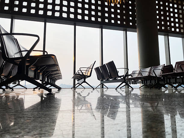 Modern airport waiting room with sleek seating, large windows providing a view, and a polished marble floor reflecting the contemporary design elements