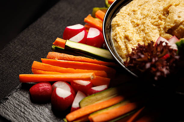 Fresh vegetable crudites with hummus dip on slate platter