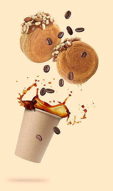 Round croissants and coffee in air on beige background