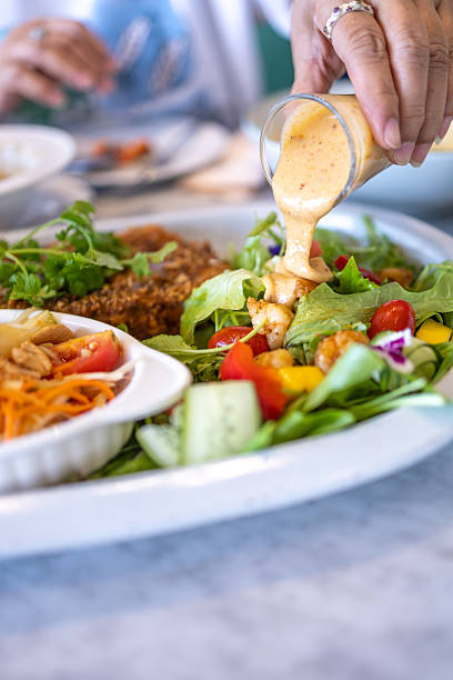 Top view of Pour the salad dressing over the vegetables, focus selective