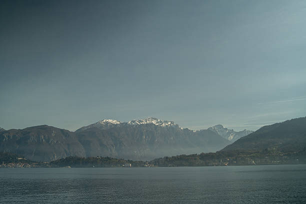 Passenger ferry boat cruising on Lake Como with scenic Italian towns and mountains in background. Travel destination in Northern Italy.