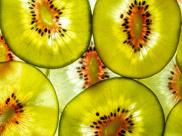 background of fresh red-hearted kiwi fruit slices backlit
