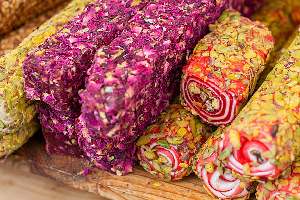 Brightly colored Turkish delight rolls, featuring unique layers of flavor, are artistically arranged at a bustling bazaar.