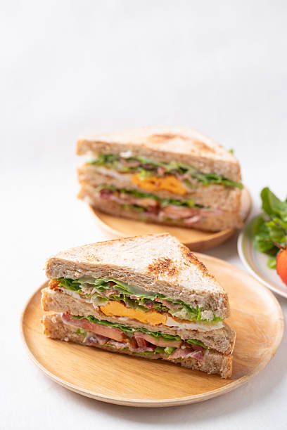 Whole wheat bread sandwich with bacon, lettuce, tomato and fried egg