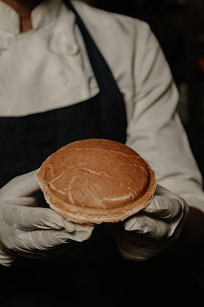 Close-Up of Baker Holding Fresh Bread Bun