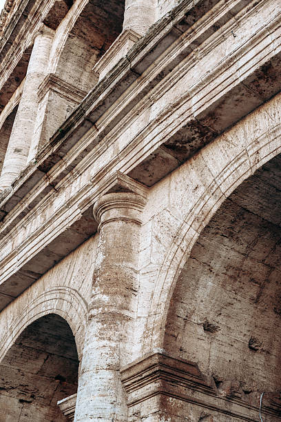 Close view of arches and columns at the Colosseum in Rome with bright light highlighting the stone.
