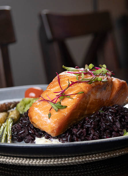 Grilled salmon fillet served over a bed of black rice.