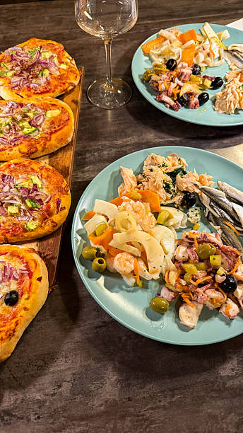 Appetizer platter with seafood salad and mini pizzas on table. Taken on mobile device