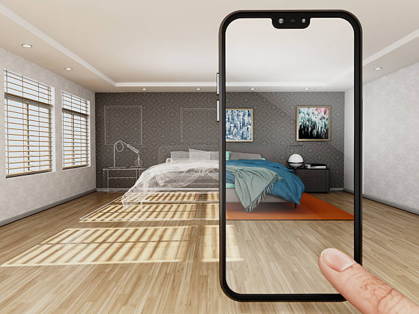 A smartphone shows a virtual modern bedroom with a large bed and colorful blankets. The room has natural light coming through windows. The walls have pictures and the floor is wooden. Artwork on the wall are from my own portfolio.