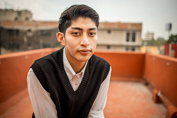 Young hispanic person confidently posing on a city rooftop with an urban background, embracing diversity and individuality