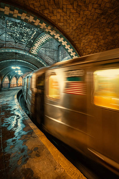 A wide angle shot of a New York City subway train passing through the Old City Hall Subway Station in Manhattan. New York City, USA.