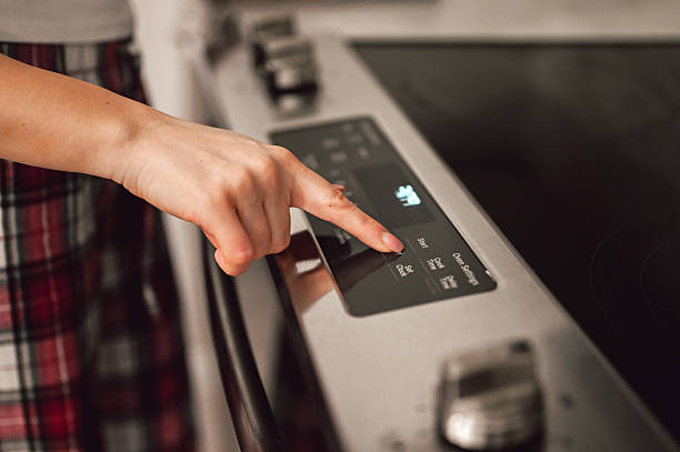 Person setting oven controls for cooking food