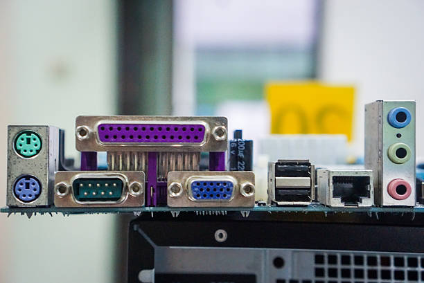 The rear I/O panel of a computer motherboard. Includes a purple DB25 parallel port, green DB9 serial port, blue VGA port, ethernet (RJ45) port, 3.5mm audio jacks.PS/2 port for mouse and keyboard, USB port.