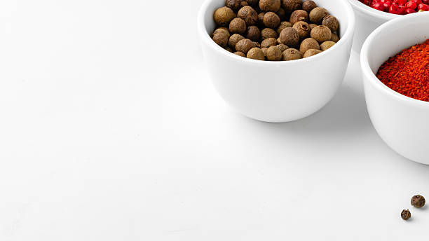 Different spices in white bowls on a plain surface during daytime