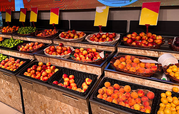 Vibrant fruit display at modern market with baskets of fresh peaches and apples