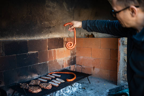 Man grilling sausages and meat outdoors