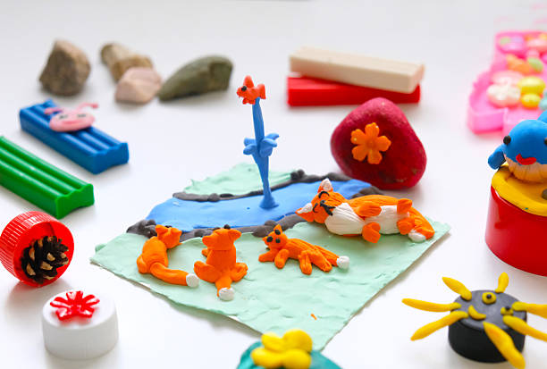 Child making crafts using natural dry plants, flowers, grass, leaves and use plastic corks, stones, plasticine, beads and paper. Back to school. Making diorama. Ideas for children's art