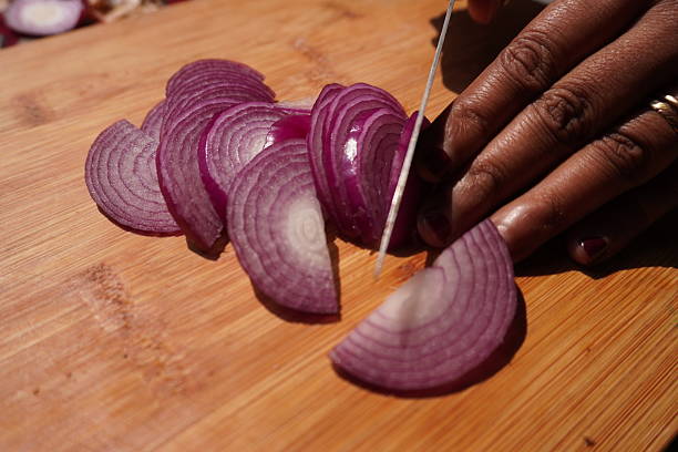 Red onions sliced on wooden cutting board