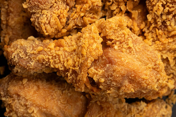 Pile of crispy fried chicken drumsticks.