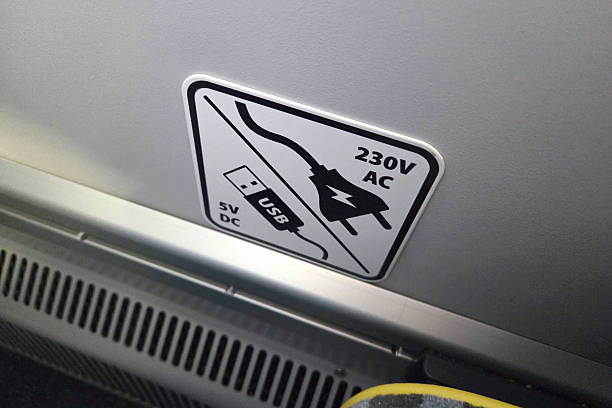 Sign showing power options for charging devices with USB and AC connections in a transport vehicle setting