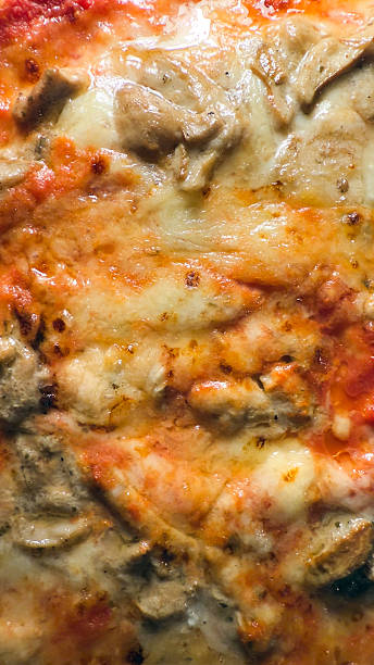 Delicious chicken and mushroom pizza baking with melted mozzarella. Taken on mobile device