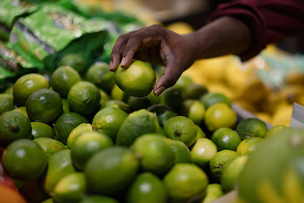 Hand picking fresh limes at grocery market