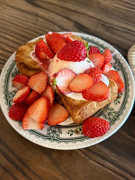 Golden French toast topped with fresh strawberries, offering a soft, custardy texture and gentle sweetness. Warm, inviting, and visually appealing, perfect for cozy breakfast or brunch moments.