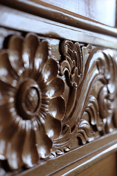 Close-up of an elegant, hand-carved wooden panel featuring intricate floral and swirl patterns.