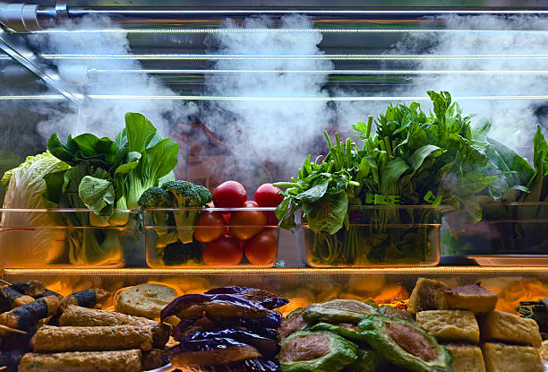 foggy refrigeration creating display with leafy greens and eggplants in glass case