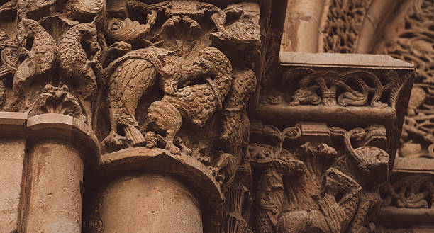Close-up details of ancient medieval european gothic architecture, showcasing weathered stone columns, sculptural reliefs, and ornamentation on a historic cathedral facade. textured surfaces, cracks.