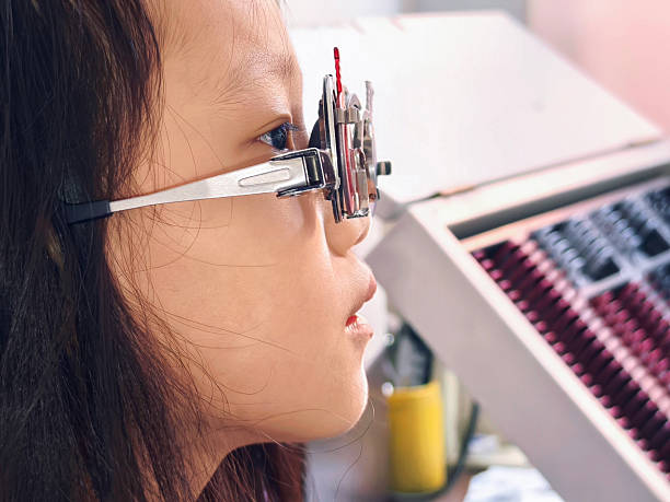 An asian girl doing a vision check in the clinic.