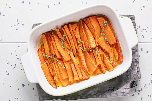 Baked sweet potatoes white thyme in a baking dish. Top view