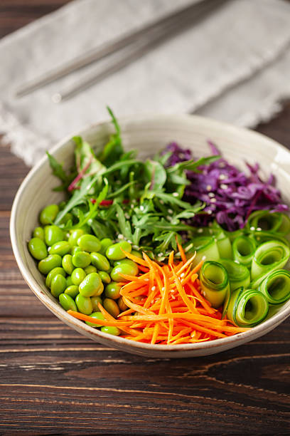 Buddha Bowl. Cucumber, carrot, arugula, red cabbage, edamame beans and sesame seeds. The concept of delicious balanced and healthy food.