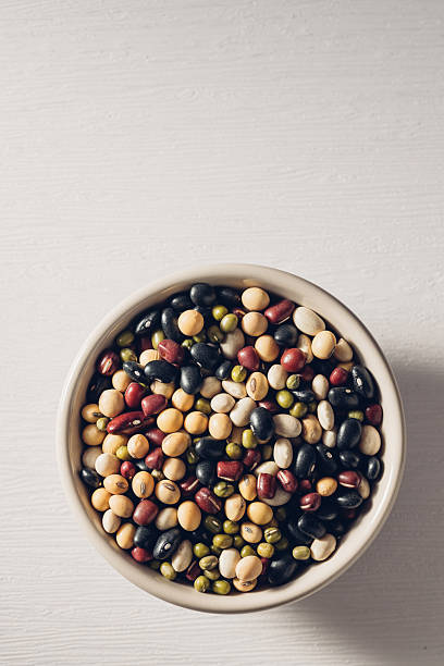 Colorful Variety of Legumes in a Bowl on a White Wooden Surface