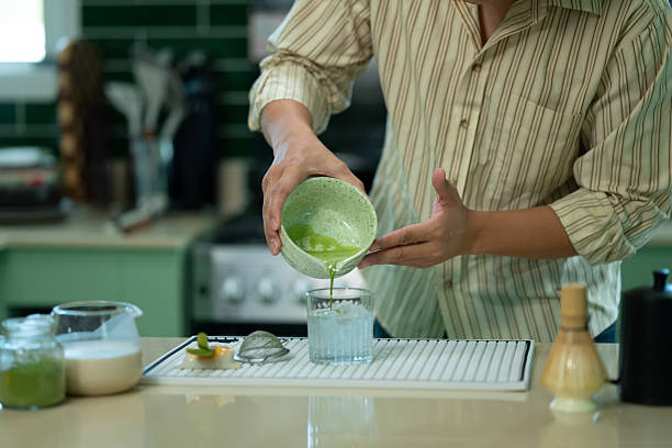 Cropped shot man adding fresh matcha to glass