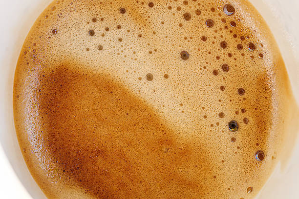 Espresso crema background Close-up top view Golden brown coffee foam with bubbles