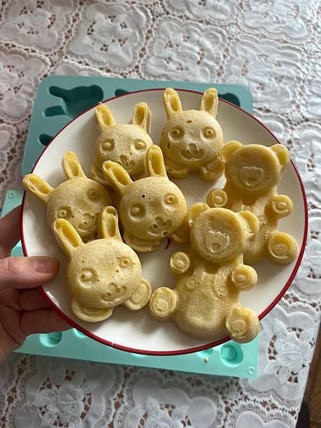 Homemade bear shaped cookies on plate held in hand