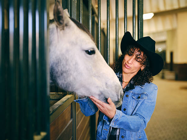 A young woman with a horse in a ranch stable. Utah USA.