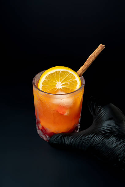 Layered Orange Citrus Energy Mocktail with Cinnamon Stick and Orange Slice Garnish, Refreshing Healthy Vitamin C Drink in Crystal Glass on Wooden Surface