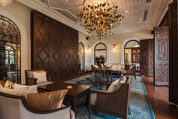 Stylish hotel lobby with wooden furniture, comfortable seating, a decorative chandelier, and classic architectural details.