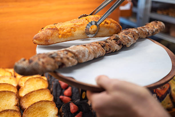Picking Fresh Artisanal Bread with Tongs in Bakery