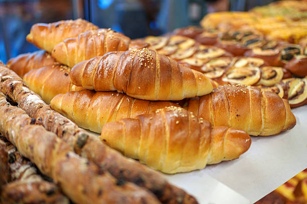 Close-up of various freshly baked fruit and nut pastries in a bakery.