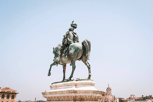 A stunning bronze statue of a man on horseback stands proudly in Rome, Italy, against a clear blue sky. The equestrian monument is a famous landmark and a popular tourist destination, showcasing the city's rich history and culture. The statue's intricate details and majestic presence make it a must-see attraction for visitors from around the world.