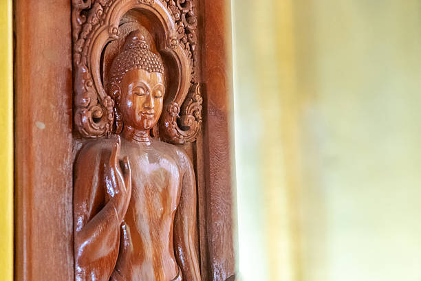 Intricate wooden Buddha carving that showcases exceptional craftsmanship. This serene sculpture captures the essence of spirituality and traditional artistry in a warm, inviting setting.
