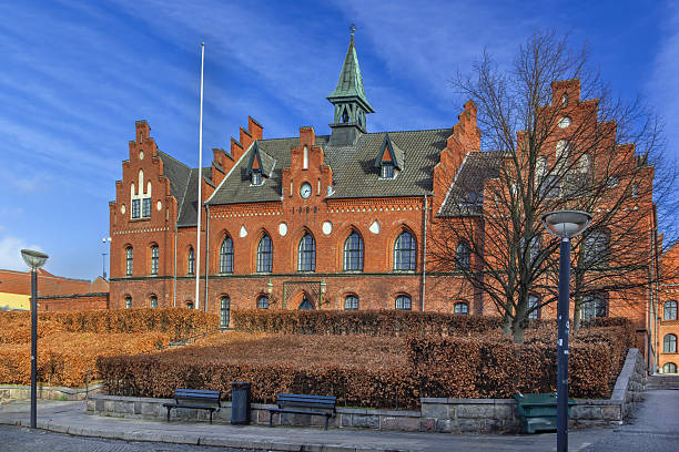 Historic red brick building with clock and 1888 date on facade, Roskilde, Denmark.