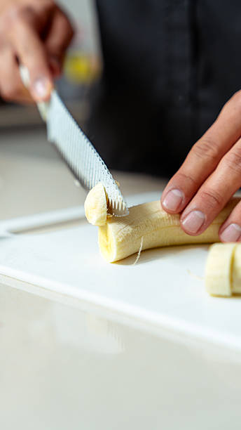 Person cutting ripe banana for healthy snack