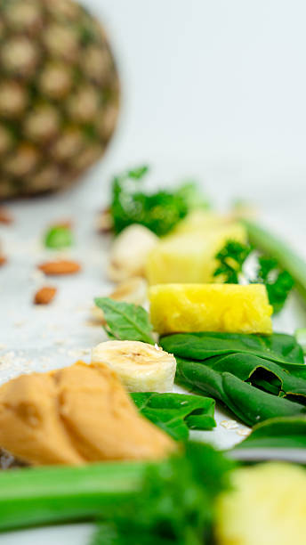 Healthy smoothie ingredients pineapple, banana, spinach, peanut butter
