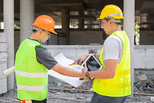 Confident team of architect working together in building construction site. They discussing about new startup project. Architect discuss with engineer about project . Architectural concept.